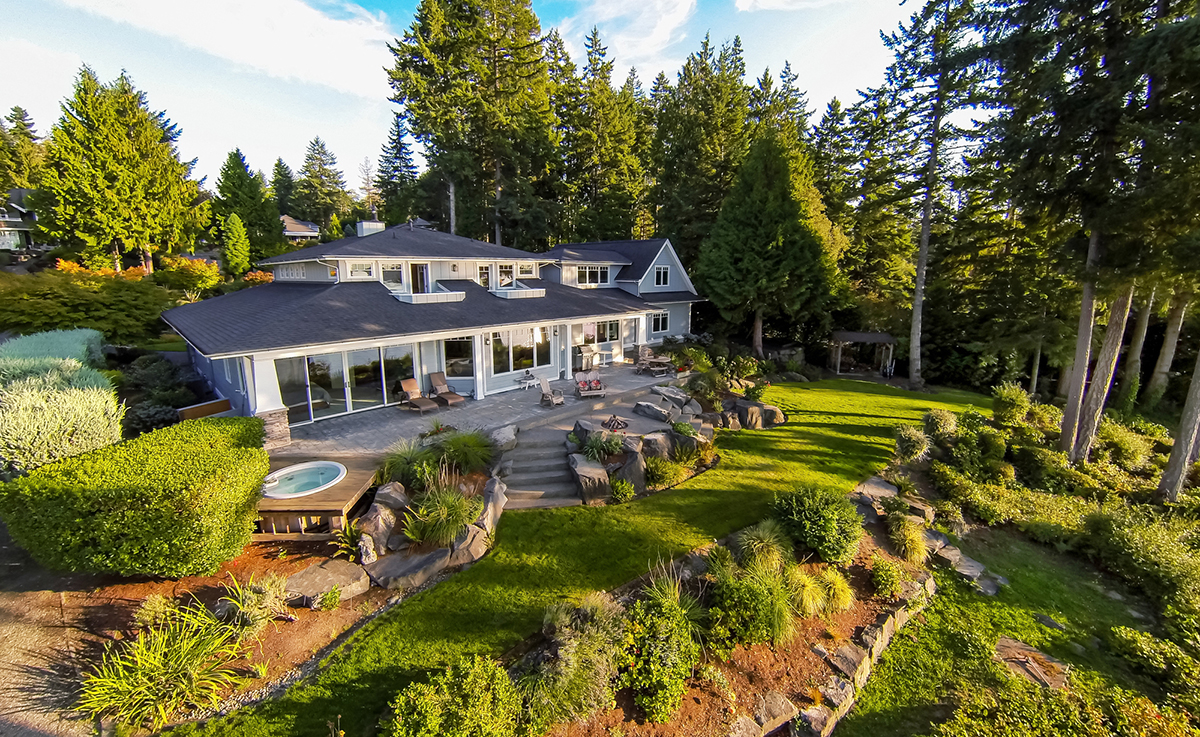 Grey house with backyard landscape design