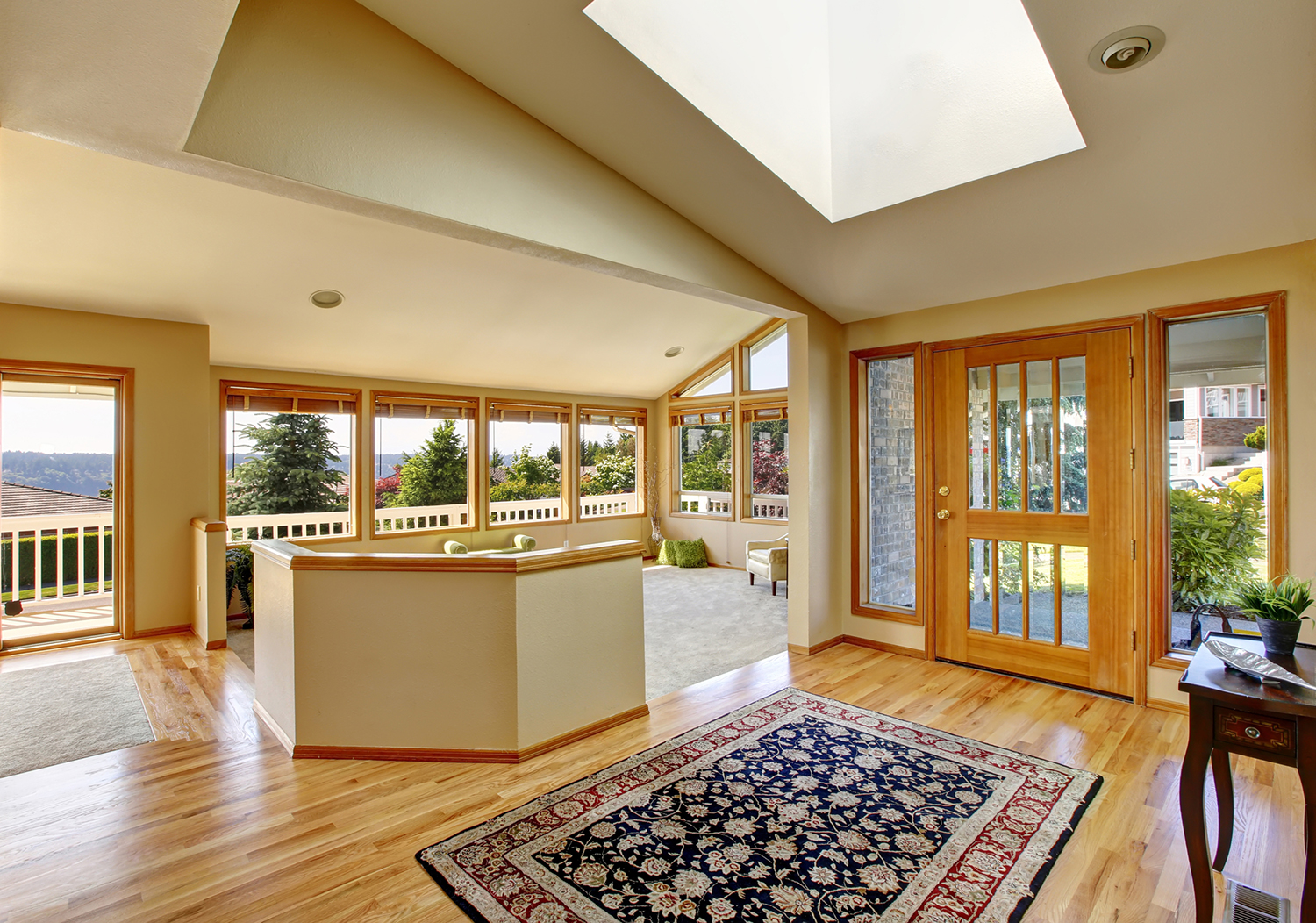 Living room with many windows and views of trees.